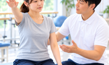 上肢挙上時の予測的姿勢制御APAを評価するセラピストと患者