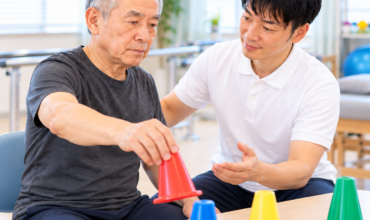 脳腫瘍治療後の患者がセラピストと一緒に上肢の協調運動トレーニングを行う様子