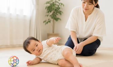 寝返りを見守る母